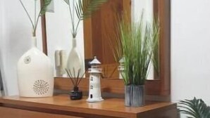A wooden desk with a mirror, a vase, and a potted plant. - Nazaré - 10 minutes from the ocean (montholon)