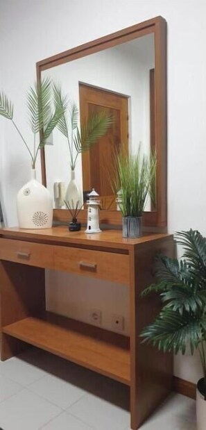 A wooden desk with a mirror, a vase, and a potted plant. - Nazaré - 10 minutes from the ocean (montholon)