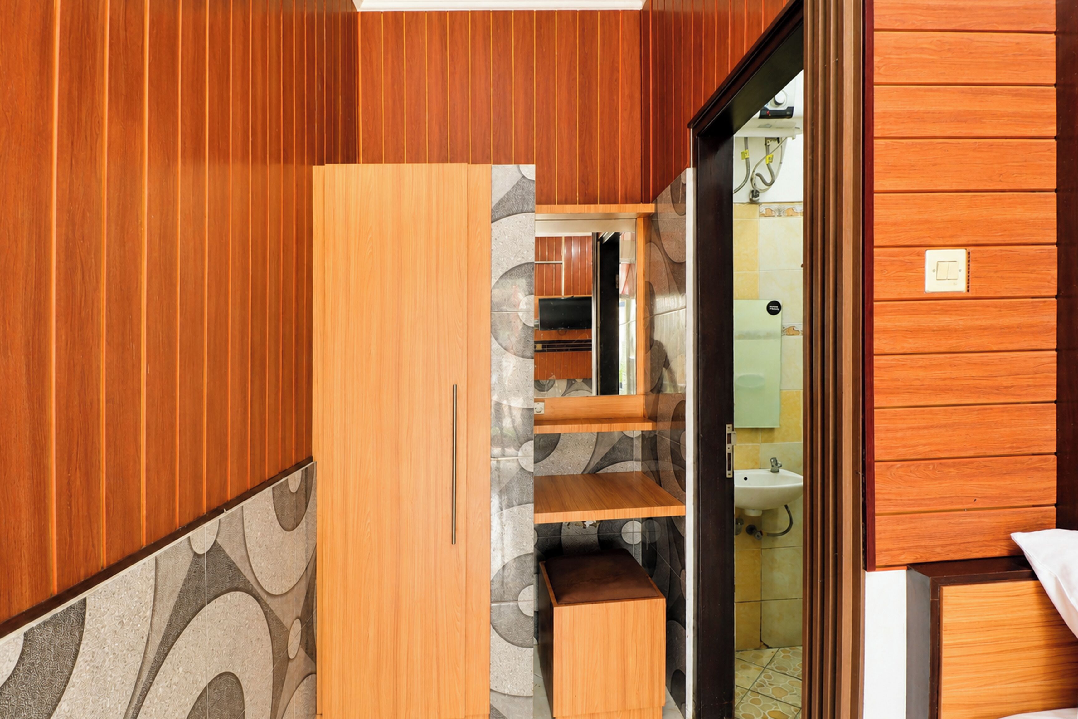 Un baño con paneles de madera, un lavamanos y un espejo.