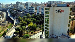 Un hôtel au design moderne, reconnaissable à son enseigne distinctive, celle de l’hôtel Cosmos.