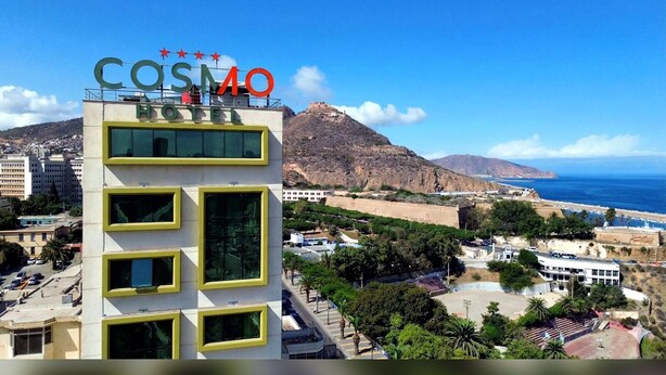 Un hôtel appelé « COSIMO » offrant une vue sur l’océan et les montagnes.