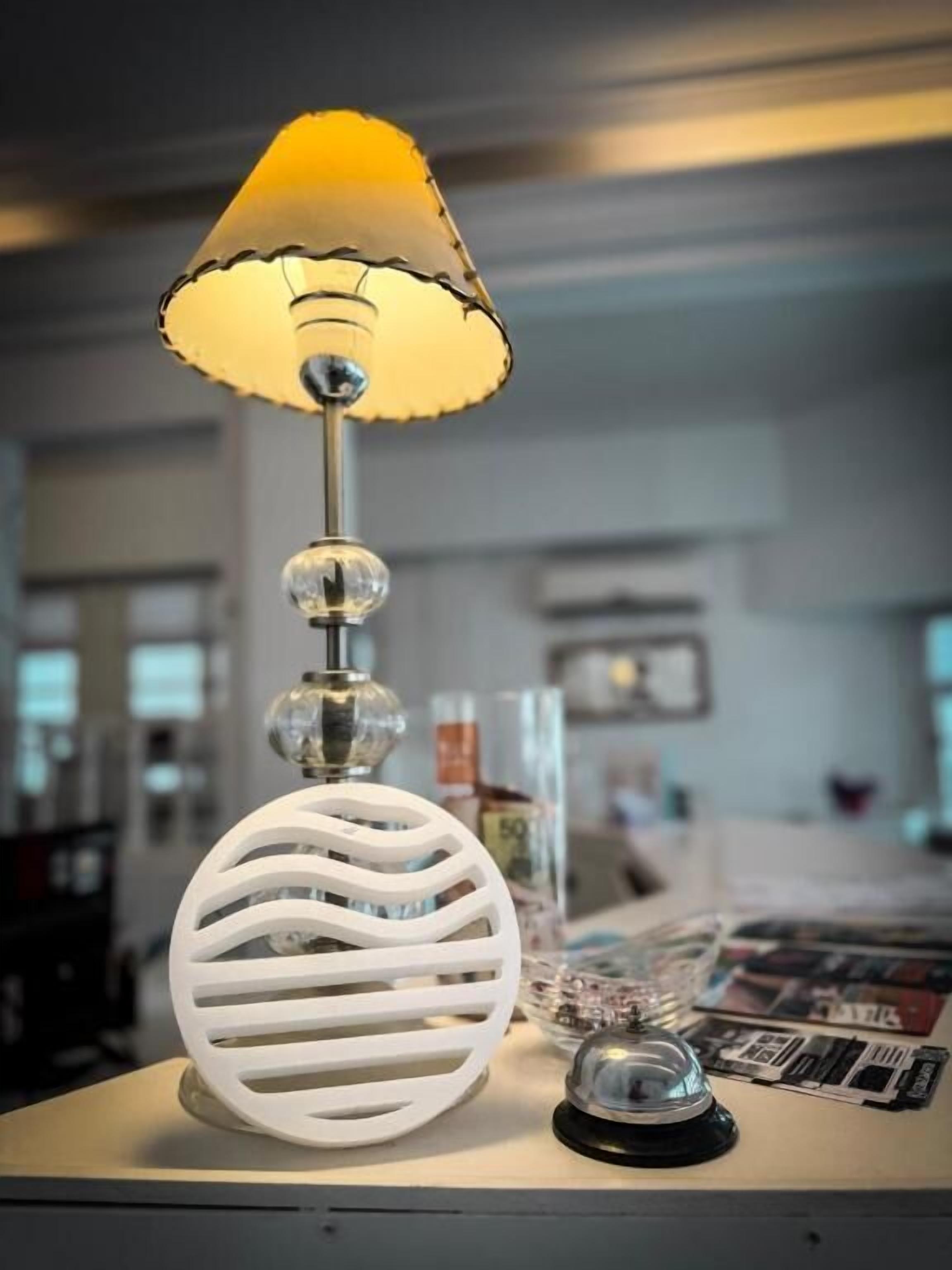 Une table avec une lampe, un globe décoratif et un petit objet noir.