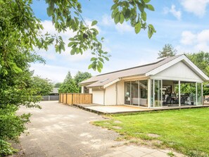 A single-story house with a covered patio area, a fenced backyard, and a paved driveway. - 12 Person Holiday Home in Oksbol (Oksbol)