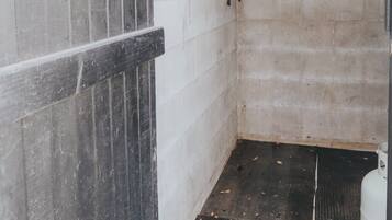 A narrow hallway with a concrete wall and a wooden door frame.