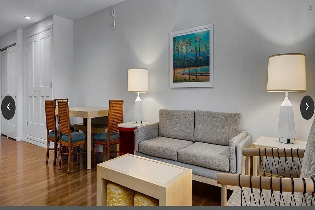 A living room with a sofa, two chairs, a table, and two lamps.