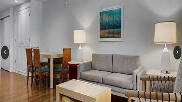 A living room with a sofa, two chairs, a table, and two lamps.
