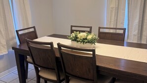 A dining room with a rectangular table, six chairs, a clock on the wall, and a chandelier. - Home Sweet Home Nearby Beach & MS Gulf Coast! (Grand Bay)
