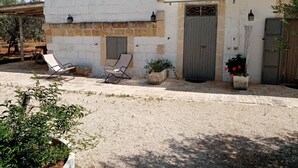 A building with a white exterior, a grey door, and a small balcony. - LA TORRETTA SHORT-TERM RENTALS (MONOPOLI)