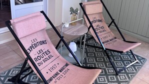 Två fåtöljer med en retroinspirerad design, placerade på en mönstrad matta.