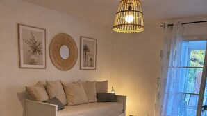 En matplats med ett träbord, stolar, en vävd bordsduk och en hängande lampa.