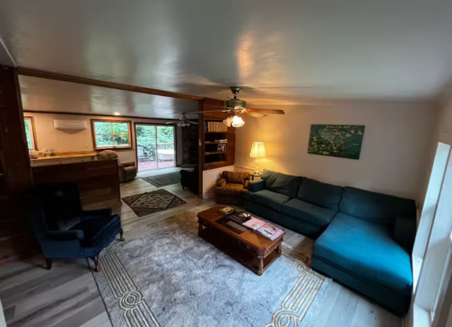 A living room with a sofa, coffee table, and a ceiling fan.