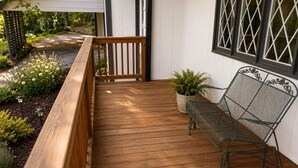Une terrasse en bois avec un banc et des plantes en pot.