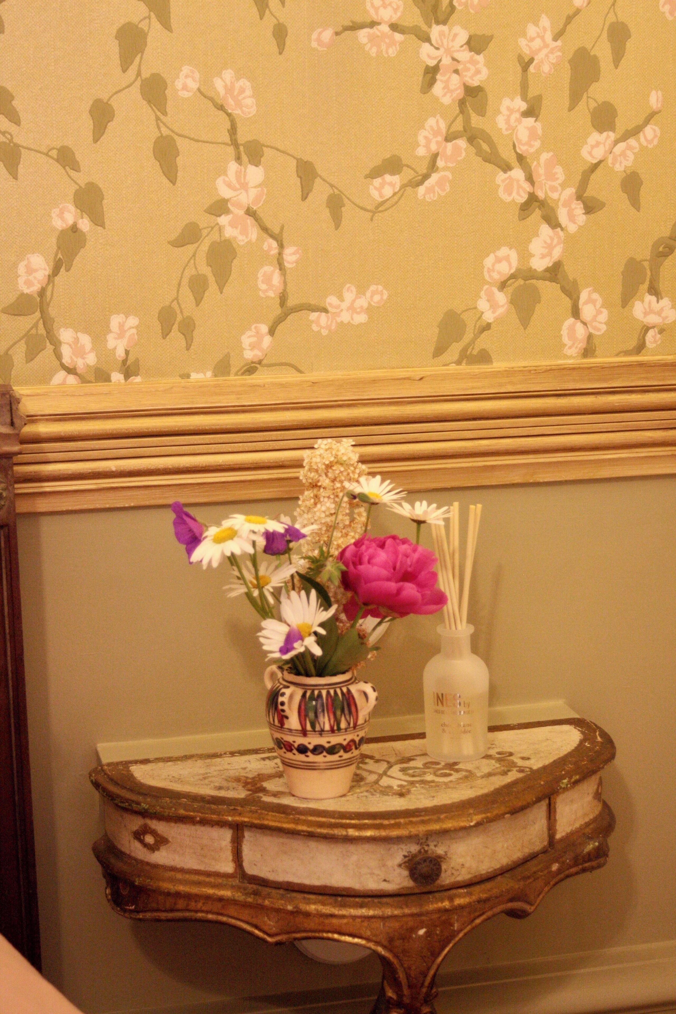 Et bord med en vase med blomster og en diffuser.