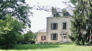 A two-story building with a symmetrical facade, a central entrance with a door, and a small porch area.