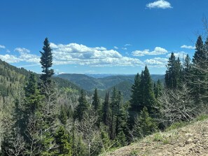 A mountainous landscape with dense forests and a clear sky.