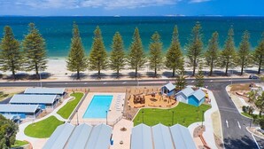 A resort with a swimming pool, beach view, and multiple buildings.