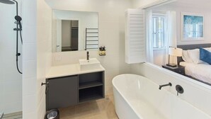 A modern bathroom with a shower, sink, and bathtub.