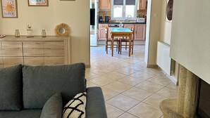 A living room with a sofa, a dining table, and a kitchen in the background. - 500 meters from the beach, a 3-bedroom family home with a terrace and barbecue (Agde)