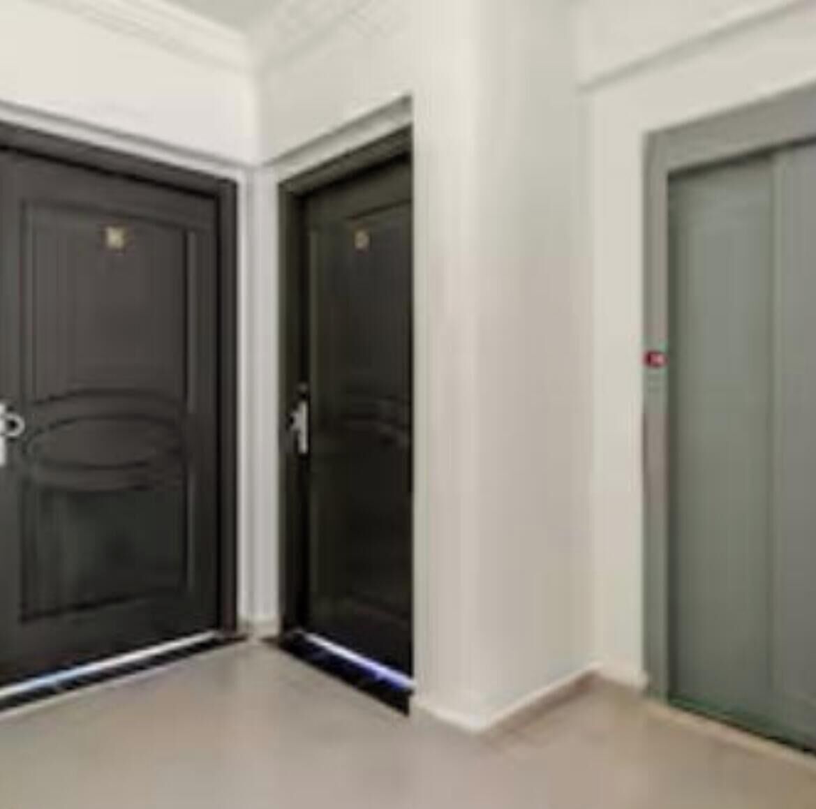 A hallway with three doors, one of which is open.