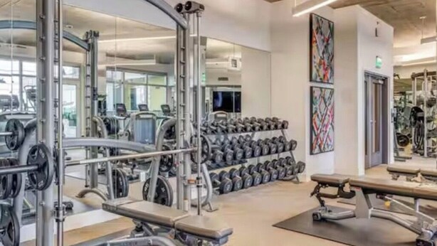 A gym with weightlifting equipment, benches, and a mirrored wall. - Luxury stay in heart of W Hollywood with free parking & pool (West Hollywood)