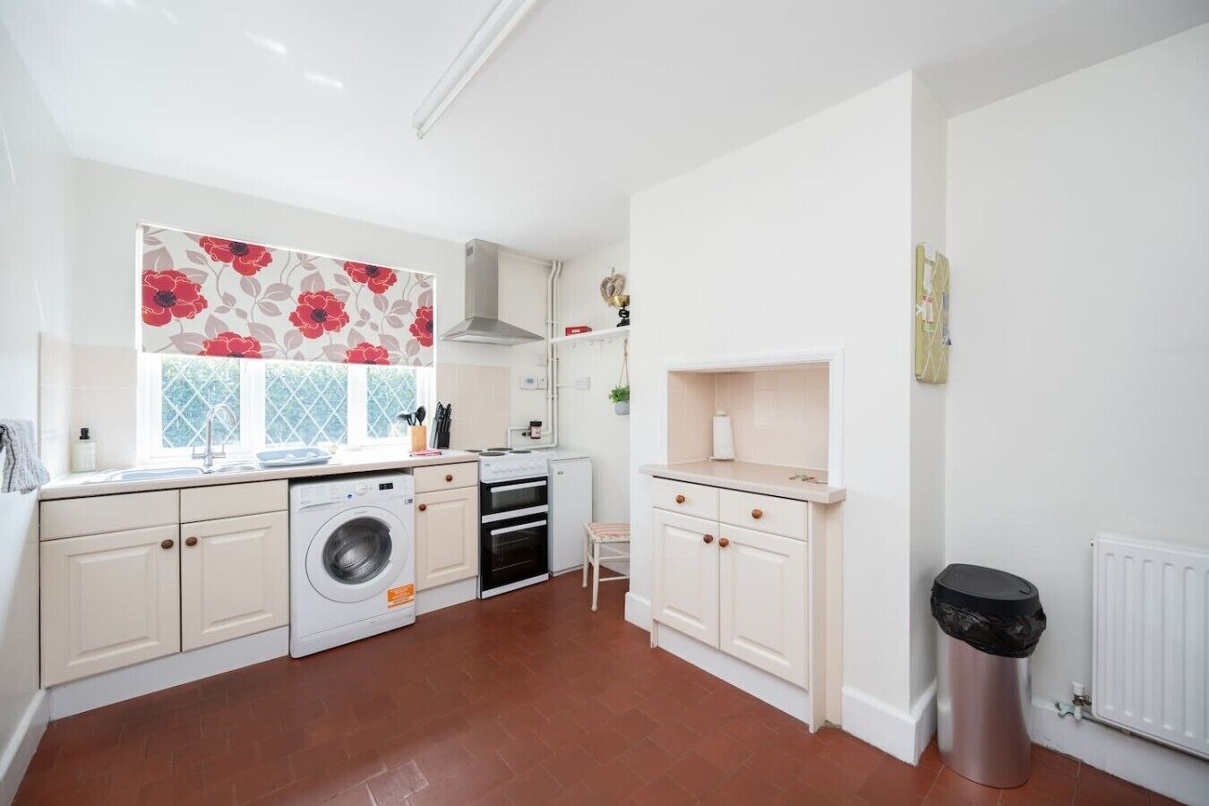 Uma cozinha compacta com máquina de lavar, forno e um pequeno espaço para refeições.