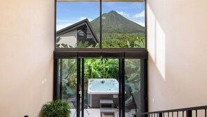 A hot tub on a balcony with a mountain view. - Modern Private Estate: 2 Homes, Jacuzzi, Cinema & Volcano Views (FORTUNA)