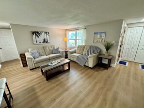 A living room with two sofas, a coffee table, and a lamp. - Fully Renovated Coastal Retreat 3BR w/ Garage & Screened Lanai (Apollo Beach)