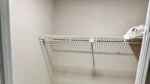 A closet with a metal rack and a wooden floor. - Fully Renovated Coastal Retreat 3BR w/ Garage & Screened Lanai (Apollo Beach)