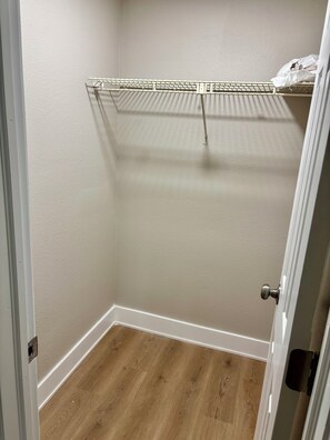 A closet with a metal rack and a wooden floor. - Fully Renovated Coastal Retreat 3BR w/ Garage & Screened Lanai (Apollo Beach)