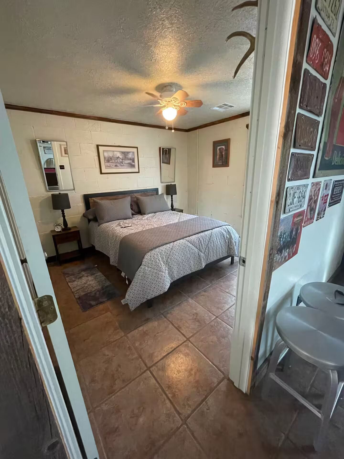 A bedroom with a bed, a nightstand, a lamp, and a ceiling fan.