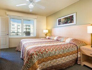 A hotel room with a bed, a nightstand, a lamp, a ceiling fan, and a window with blinds. - Seaside!! Condo with view, Balcony, Grill, just steps to the beach! (Seaside)