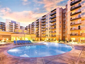 A multi-story hotel with a swimming pool, outdoor seating, and balconies. - Seaside!! Condo with view, Balcony, Grill, just steps to the beach! (Seaside)