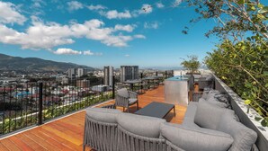 Eine Dachterrasse mit Außenmöbeln und Blick auf die Stadt, ausgestattet mit einem Holzboden.
