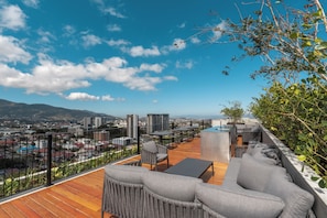 Eine Dachterrasse mit Außenmöbeln und Blick auf die Stadt, ausgestattet mit einem Holzboden.
