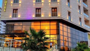 Un hotel con fachada moderna, múltiples ventanas y una entrada visible.