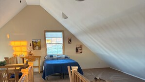 A bedroom with a bed, a desk, a chair, a window, and a staircase. - Pleasant 4-bedroom house in Centennial perfect for family getaways (Centennial)