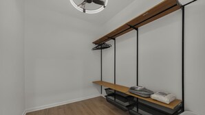 A room with a wooden bench, black metal shelving, and a white wall. - Design Lover’s 1br Suite (Atlanta)