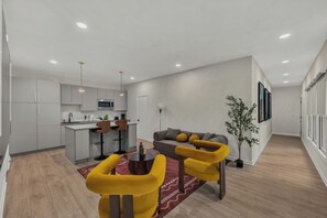 Ein modernes Apartment mit Küche, Essbereich und Wohnzimmer.