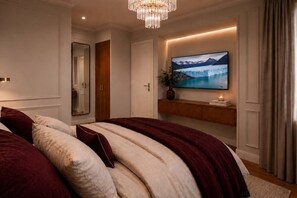 A bedroom with a large bed, a mounted TV, a mirror, and a wooden shelf with a plant and candle. - River Haven | Walk Puerto Madero Dock, Casino BA (Buenos Aires)
