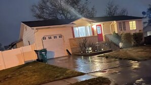 Ein Wohnhaus mit Garage, einer Veranda und einer Auffahrt.