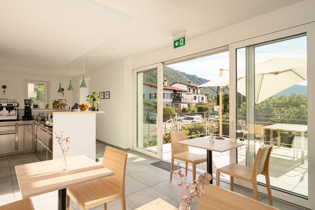 Ein modernes Hotelzimmer mit Küche, Essbereich und einem Balkon mit Bergblick.