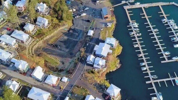 An aerial view of a residential area with houses, a road, and a marina with boats. - Cozy Ocean Gateway at Spirit Bay Pet-friendly (Sooke)
