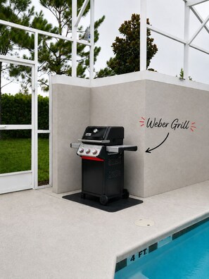 Ein Weber-Grill in Poolnähe, mit einer 1,2-Meter-Wassertiefenmarkierung.