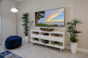 A modern living room with a white console table, a blue bean bag, and potted plants. - Luxury Disney Retreat: Private Pool + ChampionsGate Resort Access (Davenport)