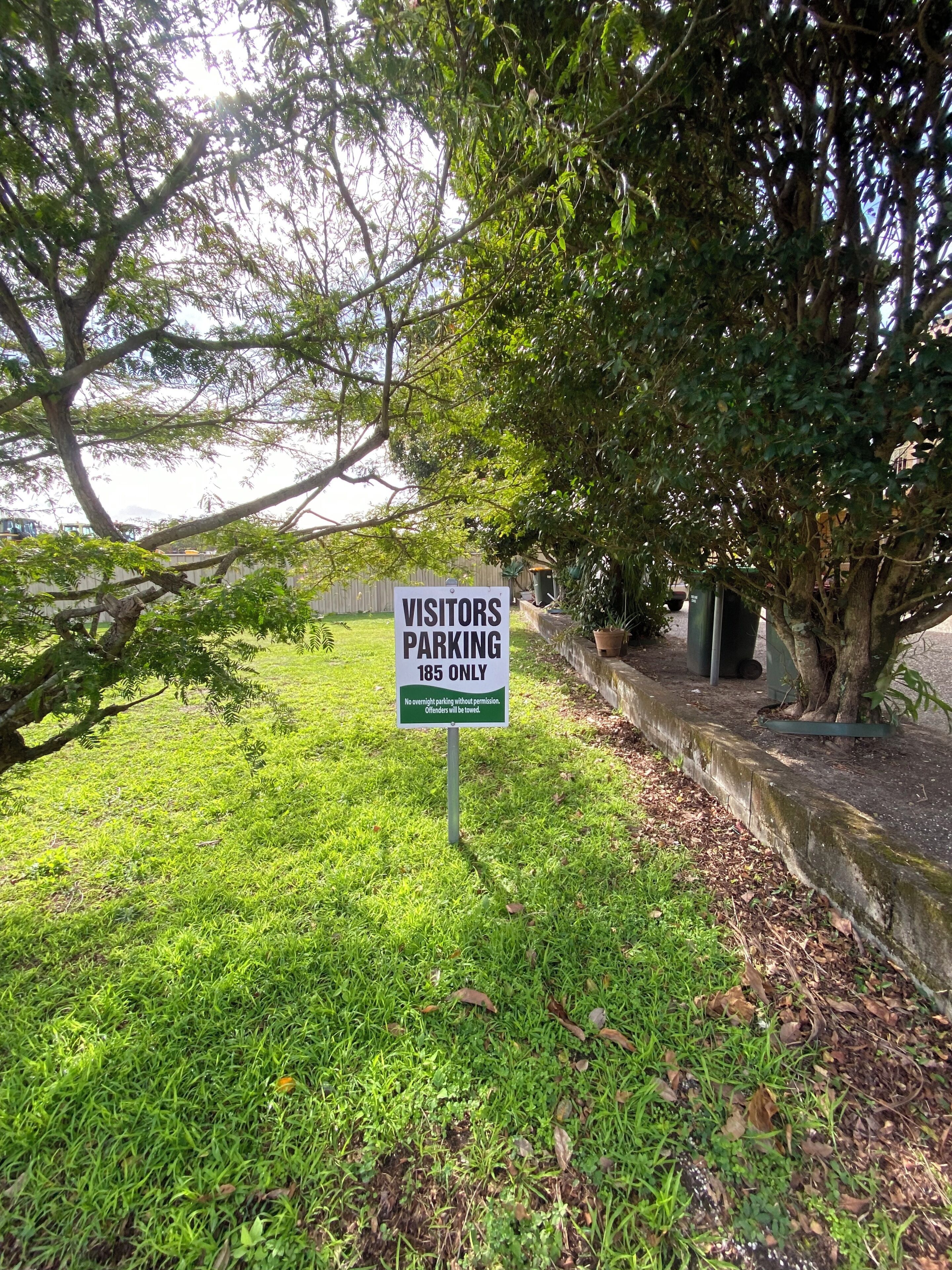 A sign indicating visitor parking is limited to 185 spaces.