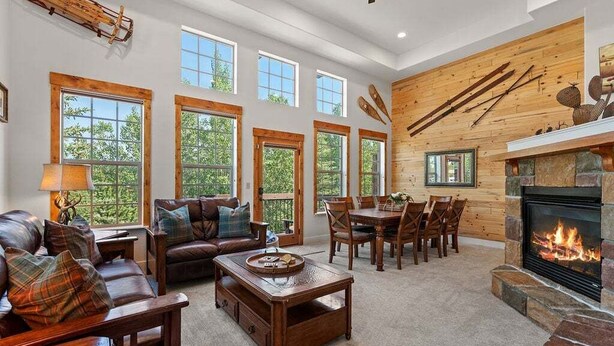 A spacious living room with a fireplace, large windows, and a cozy seating area. - Downtown WP Villa 709 I Private Hot Tub I Views I Bunk Room I Desk I Discounted Attractions (Winter Park)