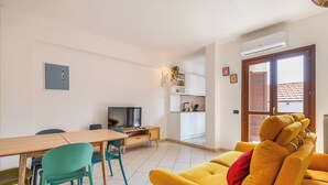 Una sala moderna con un sofá, una mesa de comedor y un televisor.