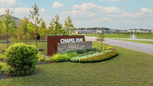 A sign reading 'CHAPEL RUN' with a landscaped area, a road, and residential buildings in the background. - Modern 3br/2.5ba • 3 king bed • Gameroom • Pets OK (Montgomery)