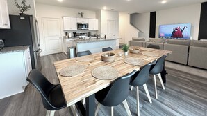 A modern kitchen with white cabinets, a microwave, and a stainless steel refrigerator. - Modern 3br/2.5ba • 3 king bed • Gameroom • Pets OK (Montgomery)