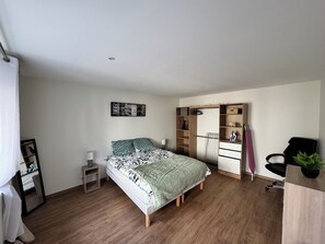 Una camera da letto con un letto, un armadio, una scrivania e una sedia.
